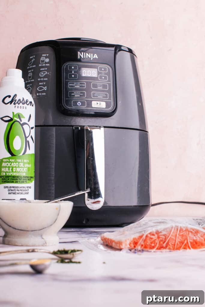 Perfectly Moist Flaky Air Fryer Frozen Salmon 4 Array of ingredients for Air Fryer Frozen Salmon, including frozen fillets, oil spray, and various spices.