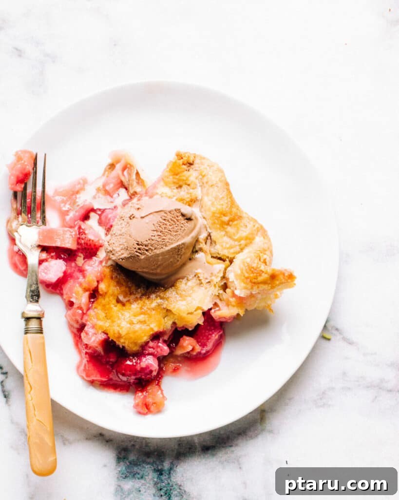 Strawberry Rhubarb Bliss 2 strawberry rhubarb pie on a plate with ice cream.