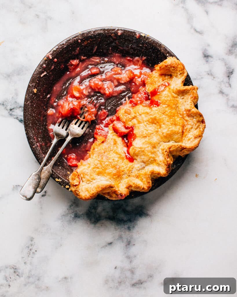 Strawberry Rhubarb Bliss 3 Strawberry rhubarb pie in a pie plate with two forks.