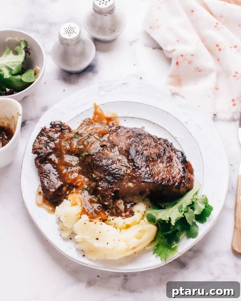 Meltingly Tender Instant Pot Steak with Rich Pan Sauce 2 Instant pot steak on a plate with mashed potatoes.