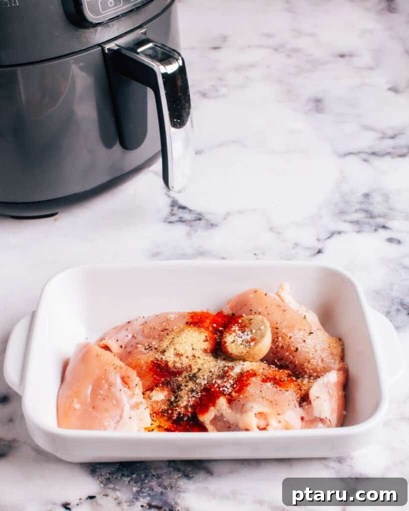 Air Fryer Boneless Thighs: Unbelievably Juicy, Incredibly Fast 4 Preparing Air Fryer Boneless Chicken by adding seasoning.