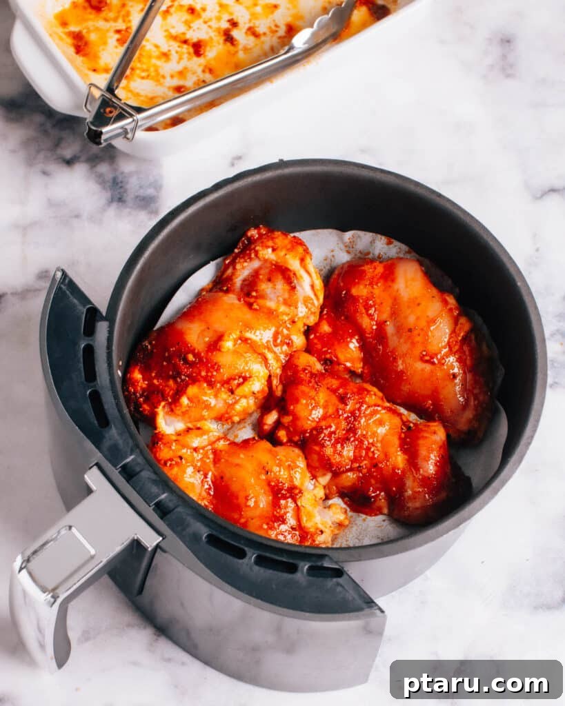 Air Fryer Boneless Thighs: Unbelievably Juicy, Incredibly Fast 6 Boneless Chicken Thighs being placed in the Air Fryer basket for cooking.