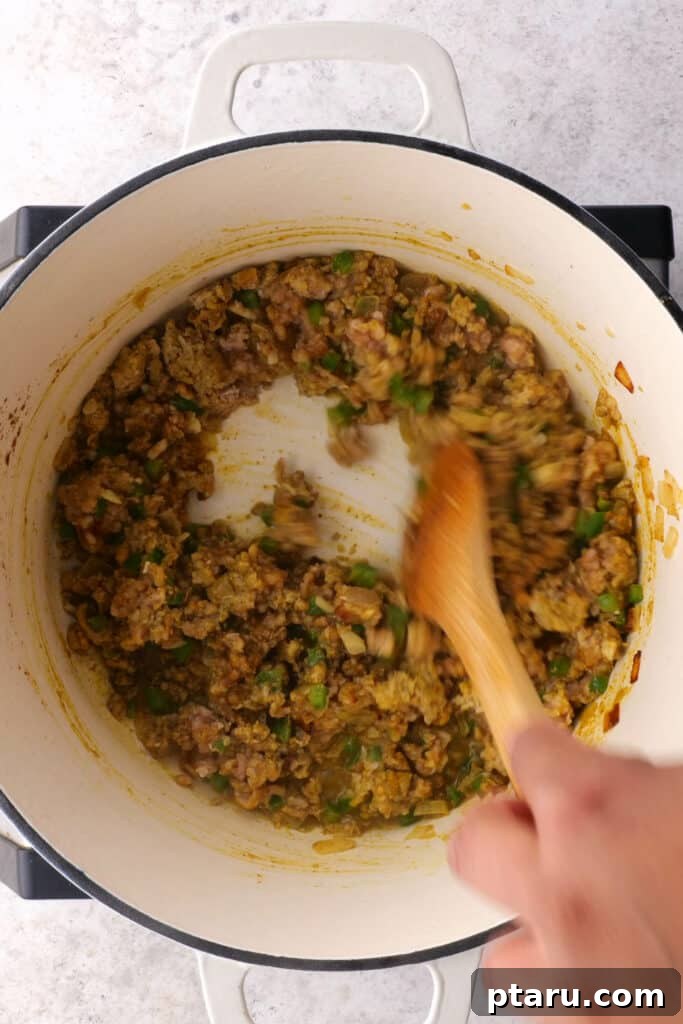 Golden Samosa Bake 5 Ground chicken or turkey is stirred in a hot pan with the sautéed onions and spices, cooking until it loses its pink color and becomes crumbly.