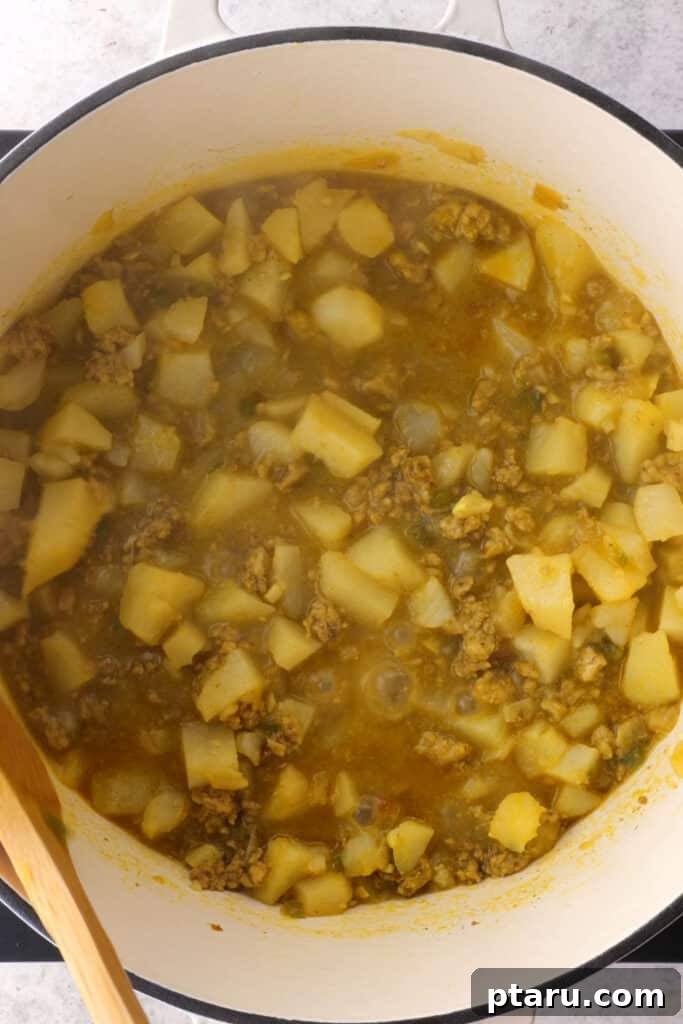 Golden Samosa Bake 6 Diced potatoes are added to the pan with the cooked ground meat, onions, and spices, ready to be simmered and infused with flavor for the Samosa Pie filling.