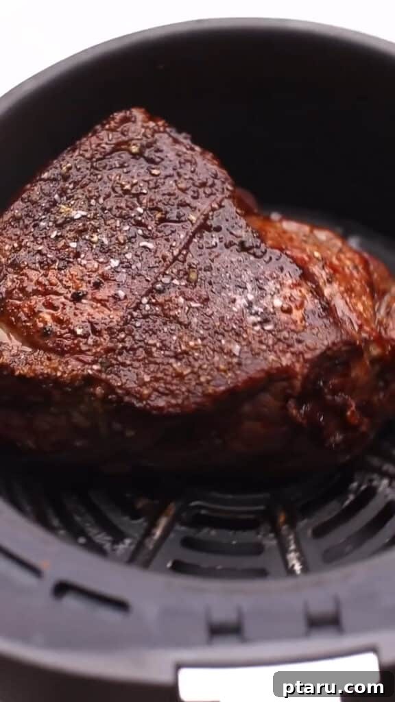 Melt in Your Mouth Air Fryer Roast Beef 6 Roasted Beef in Air Fryer basket, perfectly browned