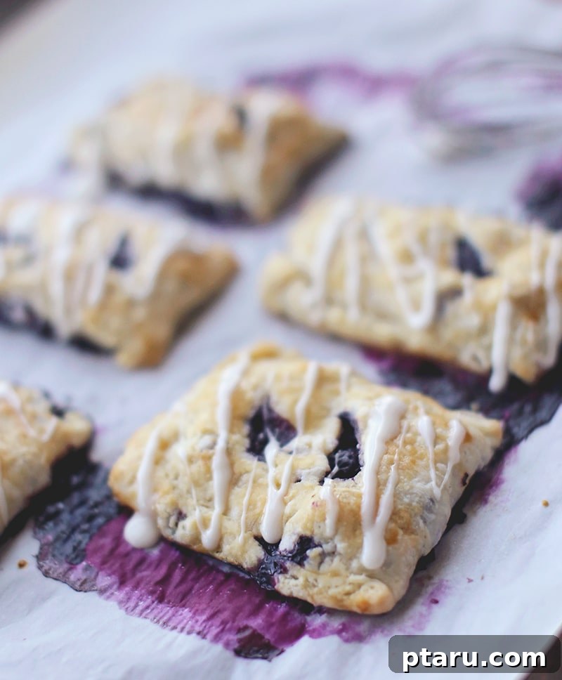 Homemade Blueberry Pocket Pies 5 A close-up shot of a blueberry hand pie with a fork, showing the warm, gooey interior.