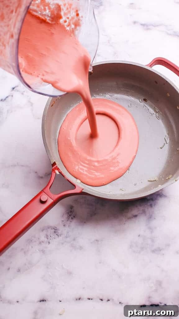 Velvety Beet Pasta Sauce 10 Pouring blended beet pasta sauce back into the pan.