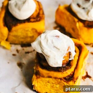 Beautifully frosted Pumpkin Cinnamon Rolls ready to be enjoyed.