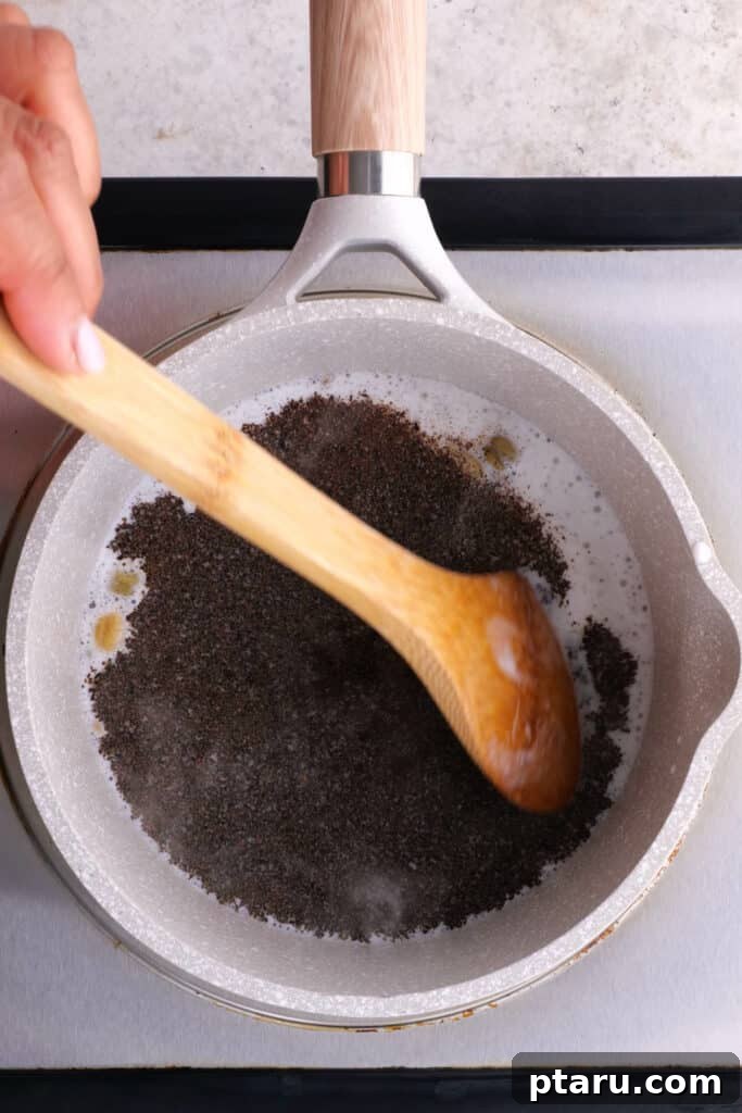 Secrets to Authentic Indian Masala Chai 4 Adding black tea leaves to the simmering milk and water mixture in a saucepan to brew chai.