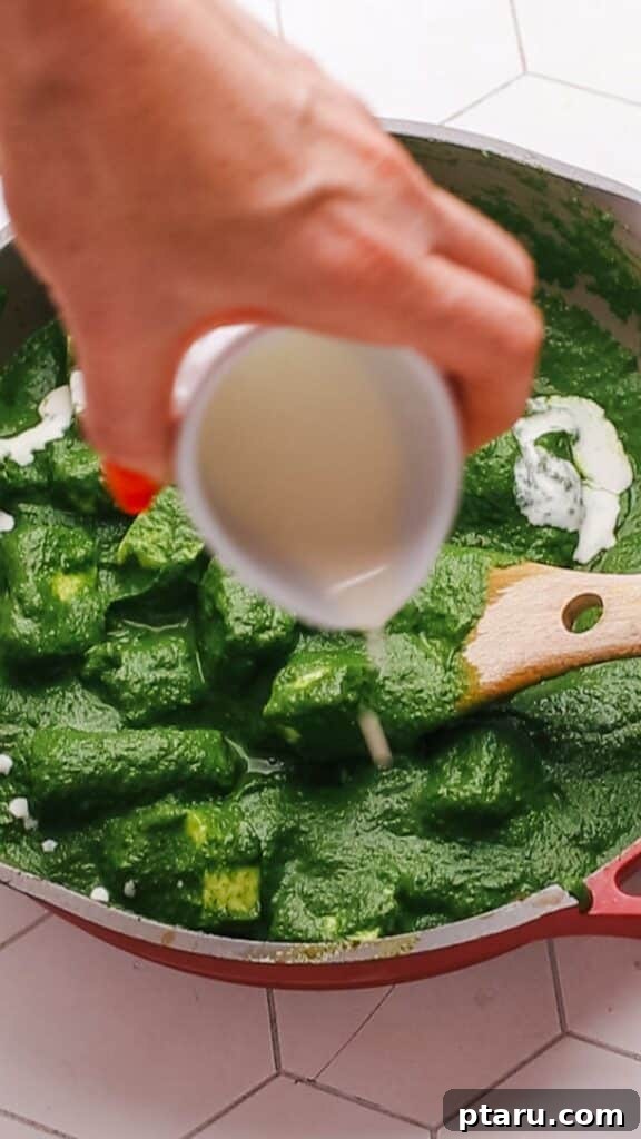 Creamy Spinach Paneer 11 Adding a drizzle of heavy cream to freshly cooked Palak Paneer