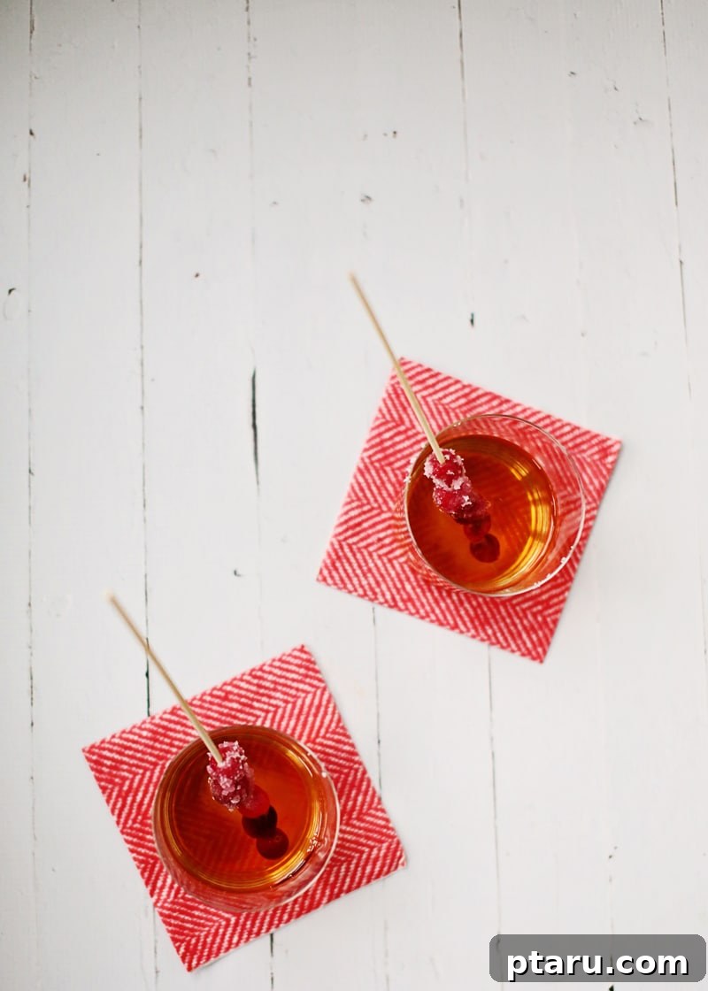 Manhattan's Merry Christmas Cocktail 3 Another close-up shot of the Merry Manhattan cocktail, highlighting its rich amber color and the elegant sugared cranberry garnish.