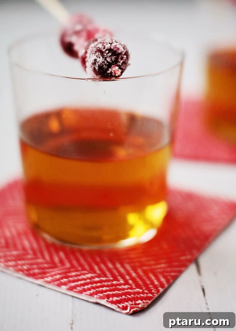 Manhattan's Merry Christmas Cocktail 5 The finished Merry Manhattan cocktail with a beautifully arranged garnish of sugared cranberries on a swizzle stick.