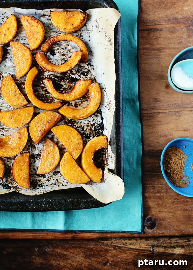 Maple Five-Spice Glazed Butternut Roast 3 A wider shot of a baking sheet filled with roasted butternut squash, showcasing its rich orange color and crispy edges.