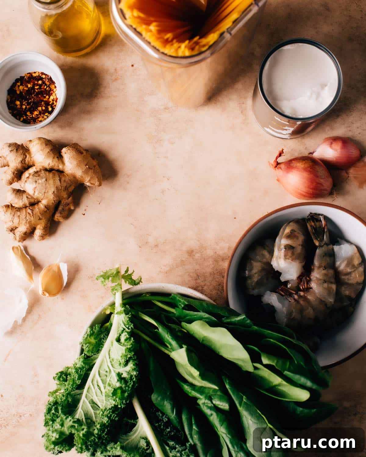 Ultimate Creamy One Pot Pasta with Greens 3 Fresh ingredients for One Pot Creamy Pasta and Greens, including kale, spinach, coconut milk, ginger, garlic, and linguine, laid out on a wooden surface.
