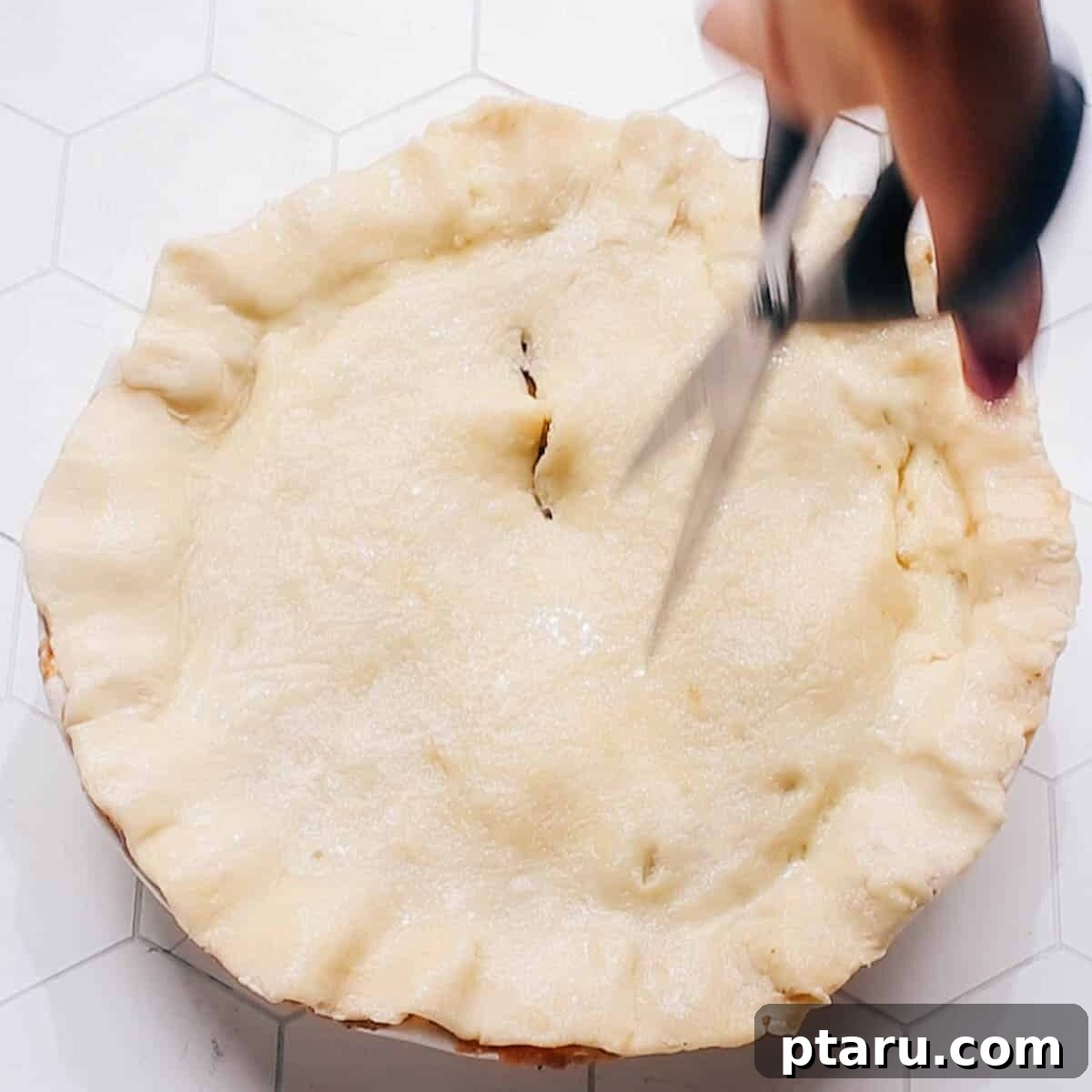 Golden-Crusted Turkey Pot Pie 7 Cutting steam vents in a beef pot pie before baking to allow steam to escape.