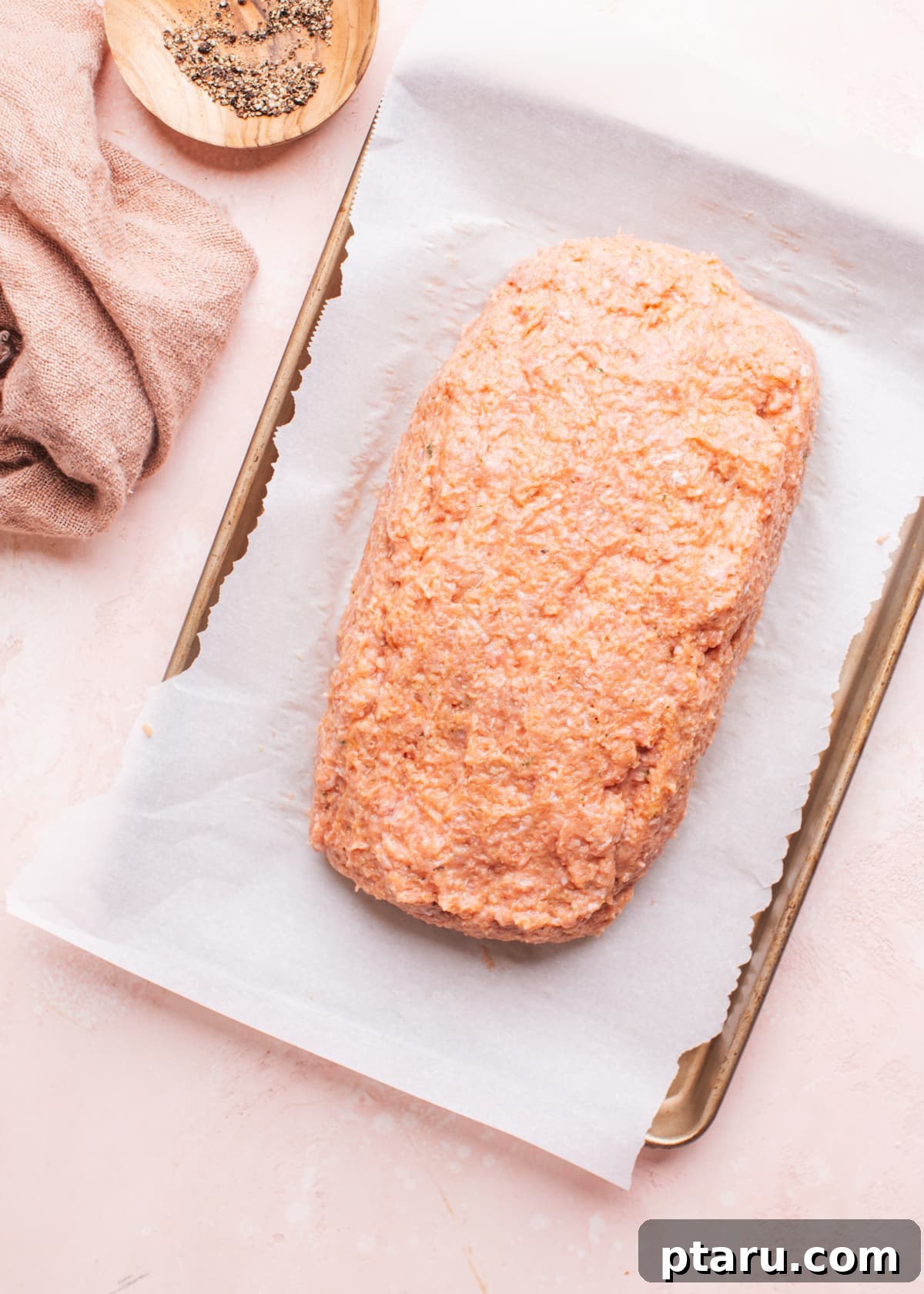 The Ultimate Juicy Turkey Meatloaf 5 Ground turkey meatloaf mixture shaped into a loaf on a parchment-lined baking sheet, ready for the oven.