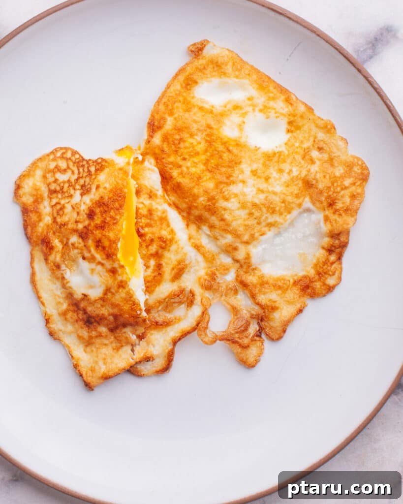 Foolproof Over Medium Eggs 4 An over medium egg cut open on a plate, revealing its creamy, partially runny yolk.