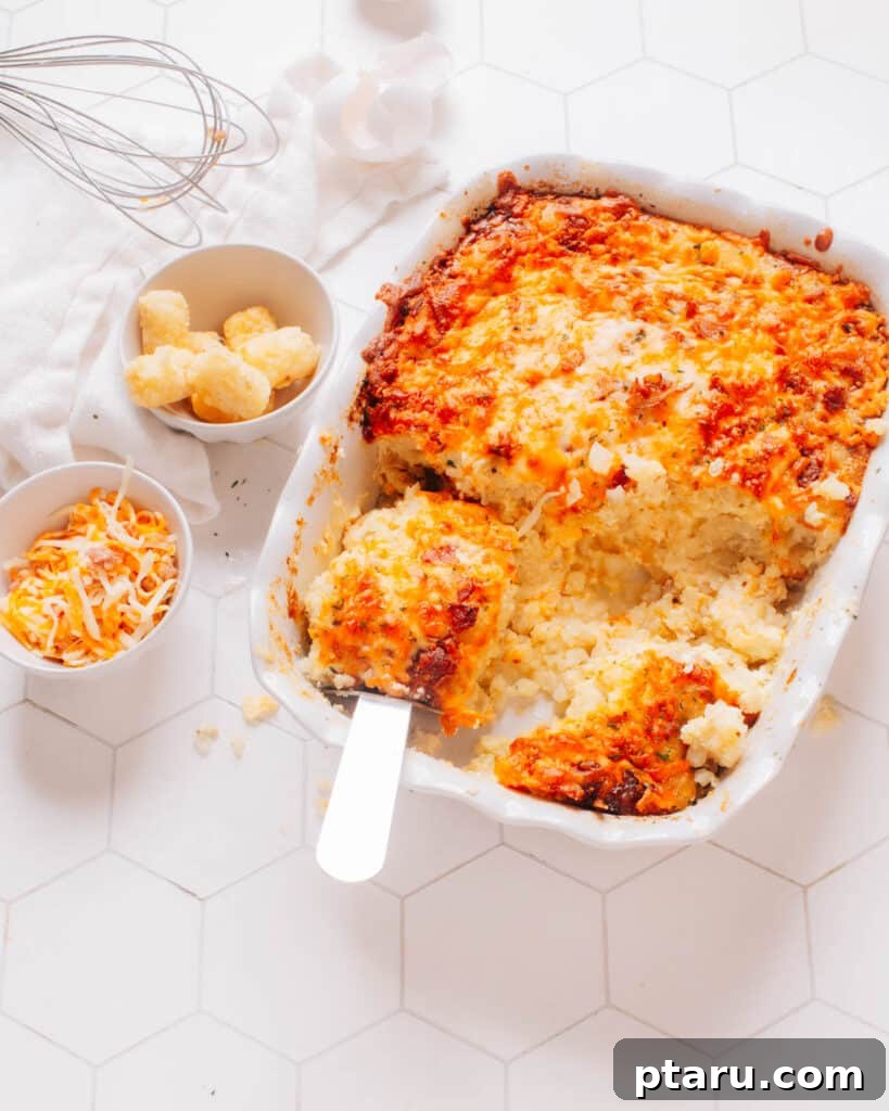 Foolproof Over Medium Eggs 7 Tater Tot Breakfast Casserole in a baking dish with a serving spoon lifting out a piece, perfect to pair with over medium eggs.