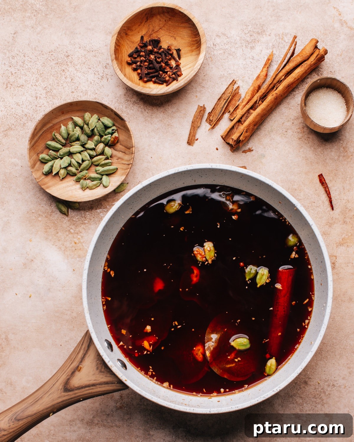 Perfectly Spiced Iced Chai Latte Made Easy 6 Whole and ground spices simmering gently in a pot of water, deeply infusing their aromas to create a rich chai concentrate base for the iced chai latte.