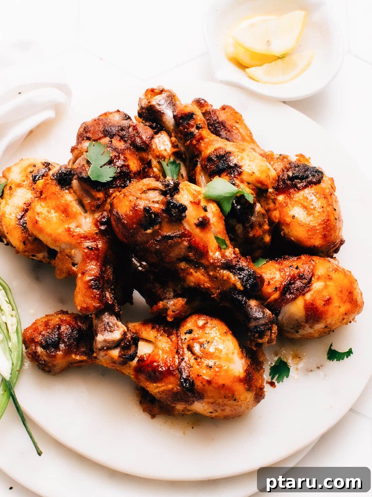 Irresistible Indian Dinners, Made Simple 16 Tandoori chicken drumsticks beautifully charred on a plate, ready to serve.