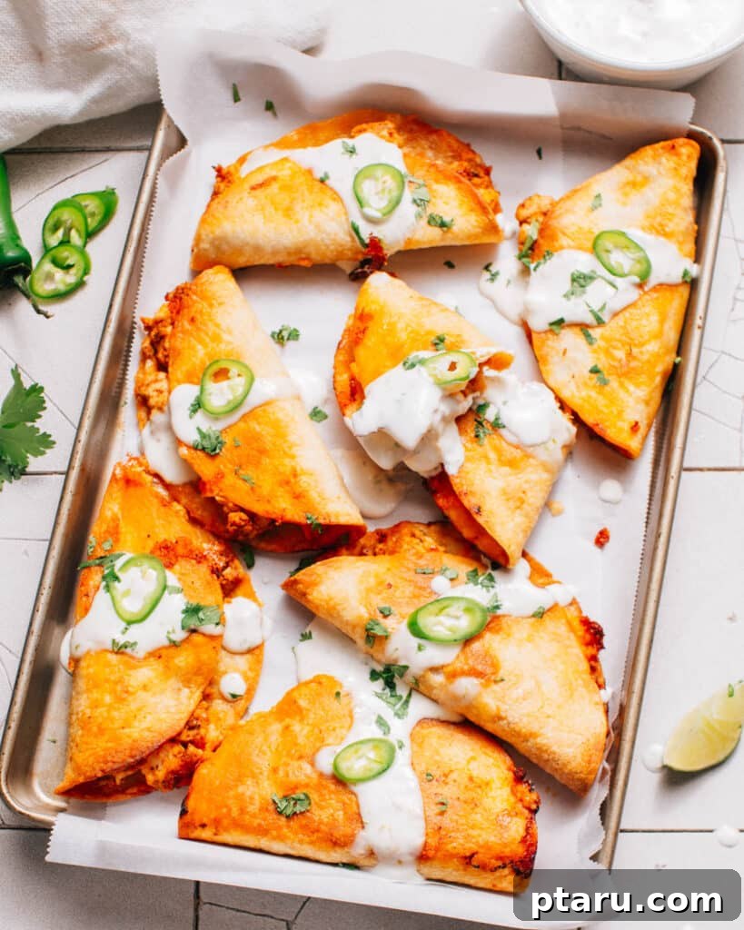 Crispy Fried Tacos Made Easy 8 A baking sheet filled with baked crispy tacos, golden brown and ready to be served.