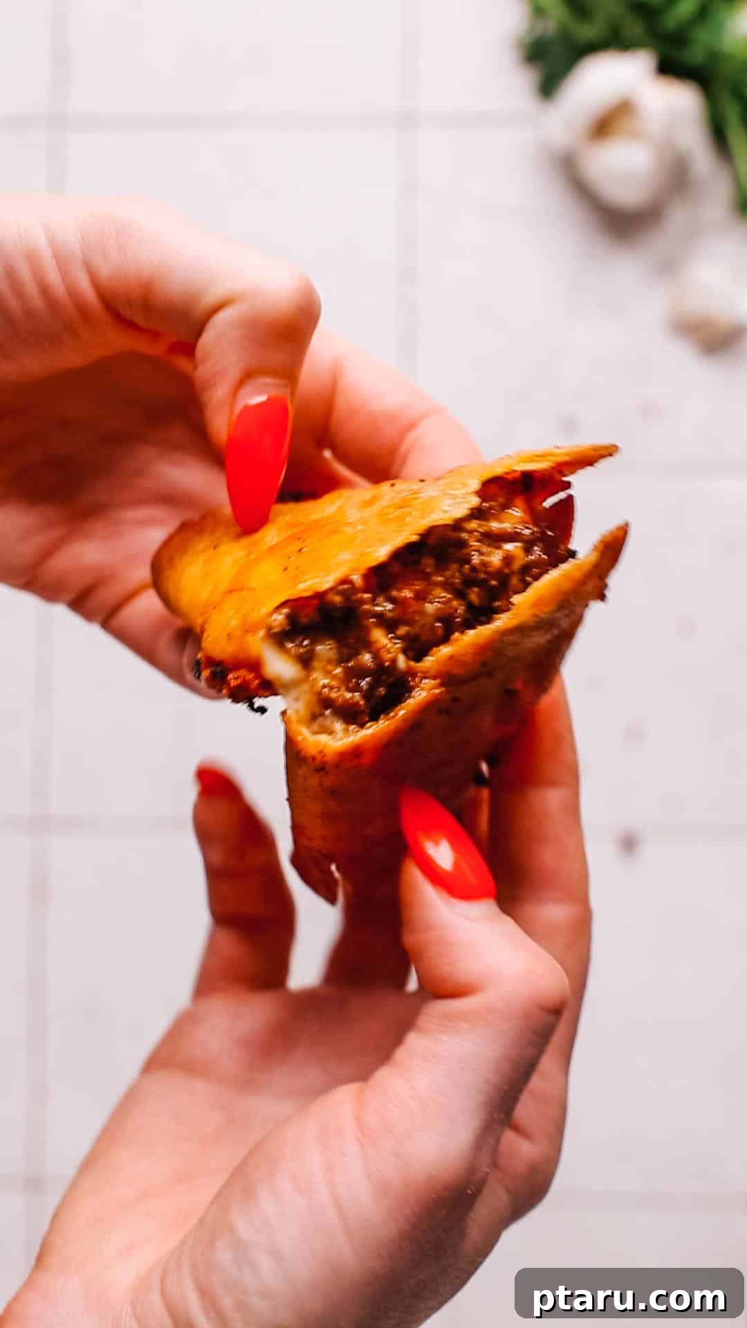 Crispy Fried Tacos Made Easy 10 A hand gently opening a freshly fried taco, ready to be filled with toppings.