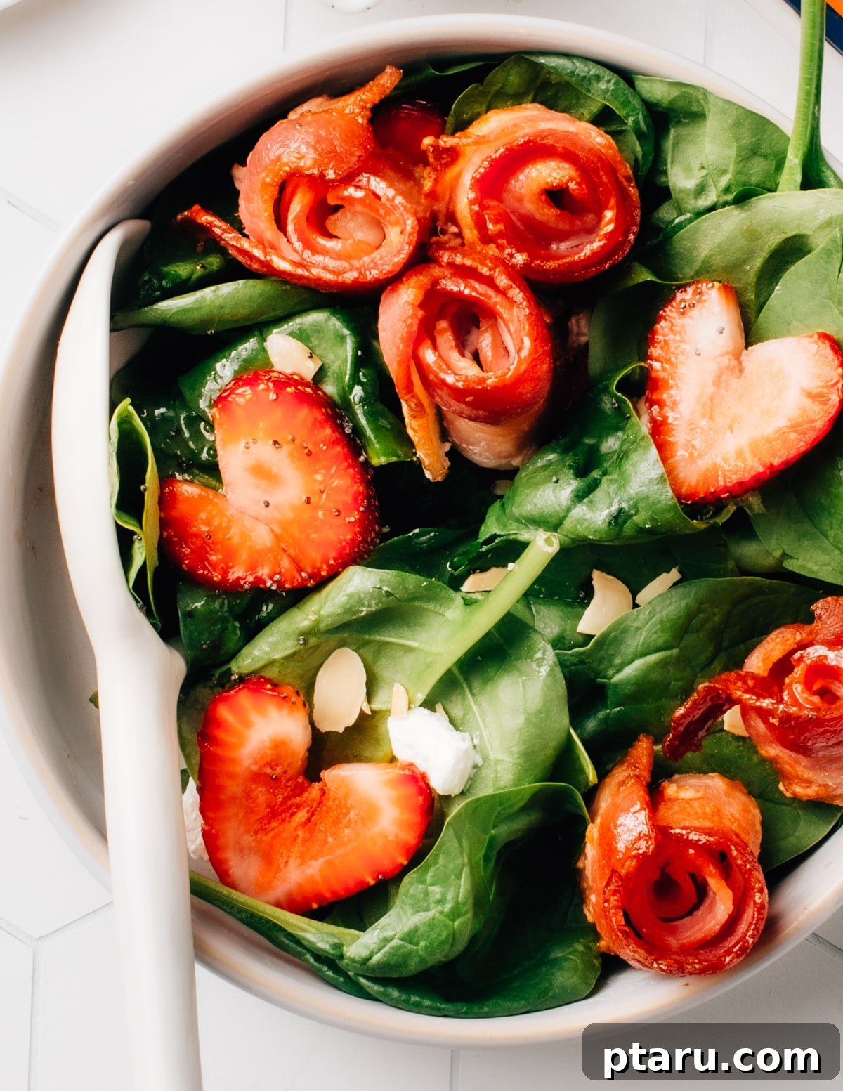 Mastering Big Batch Crispy Bacon in Your Air Fryer 3 A vibrant spinach salad generously topped with fresh strawberries and perfectly air-fried bacon pieces, showcasing its versatility.