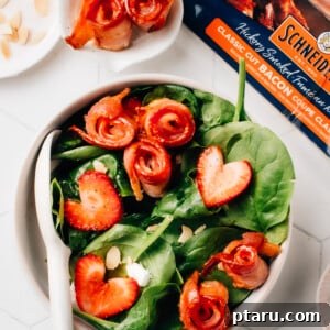 Crispy air fryer bacon on top of a spinach salad with strawberries.