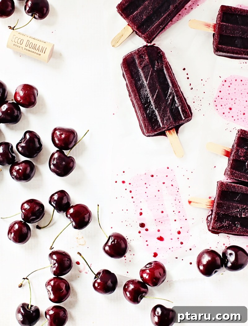 Winesicles Just Three Ingredients 4 Hand holding a refreshing cherry Merlot winesicle, showing its vibrant red color and icy texture.