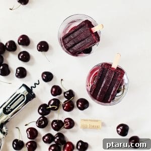 Wine popsicles (or winesicles) surrounded by fresh cherries, highlighting the main ingredients.