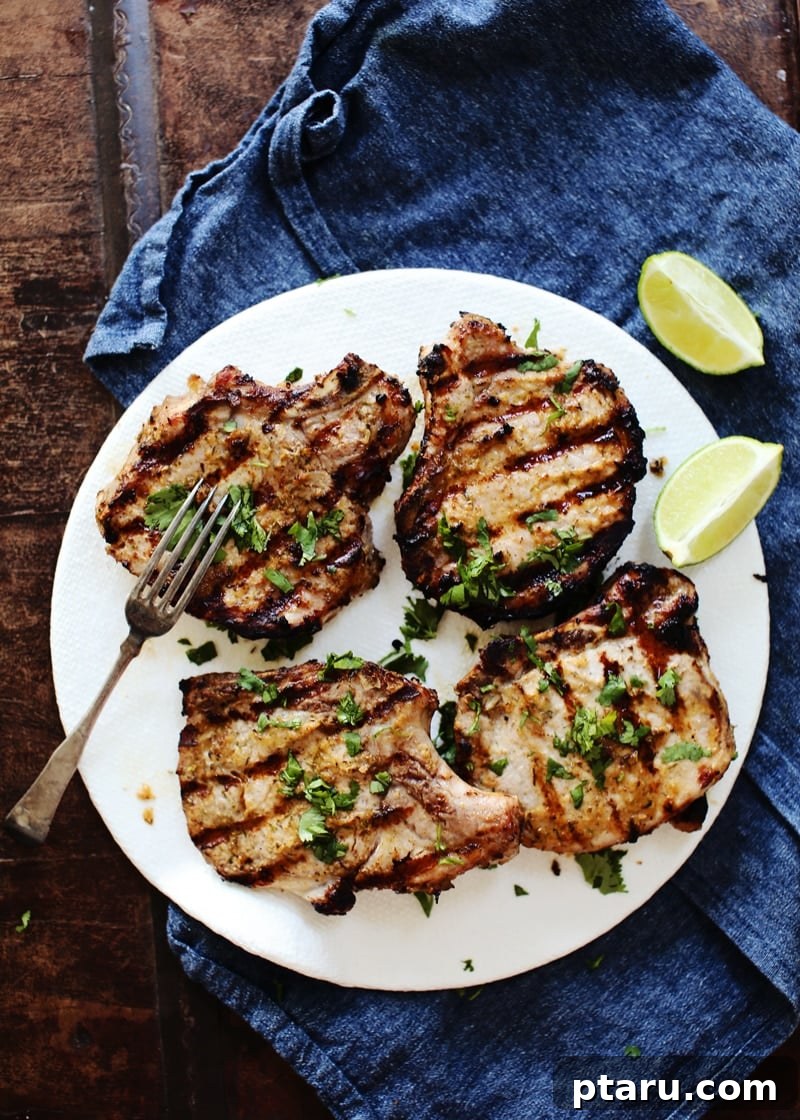 Zesty Grilled Jerk Pork Chops 2 A perfectly grilled jerk pork chop, garnished with fresh cilantro and lime wedges.