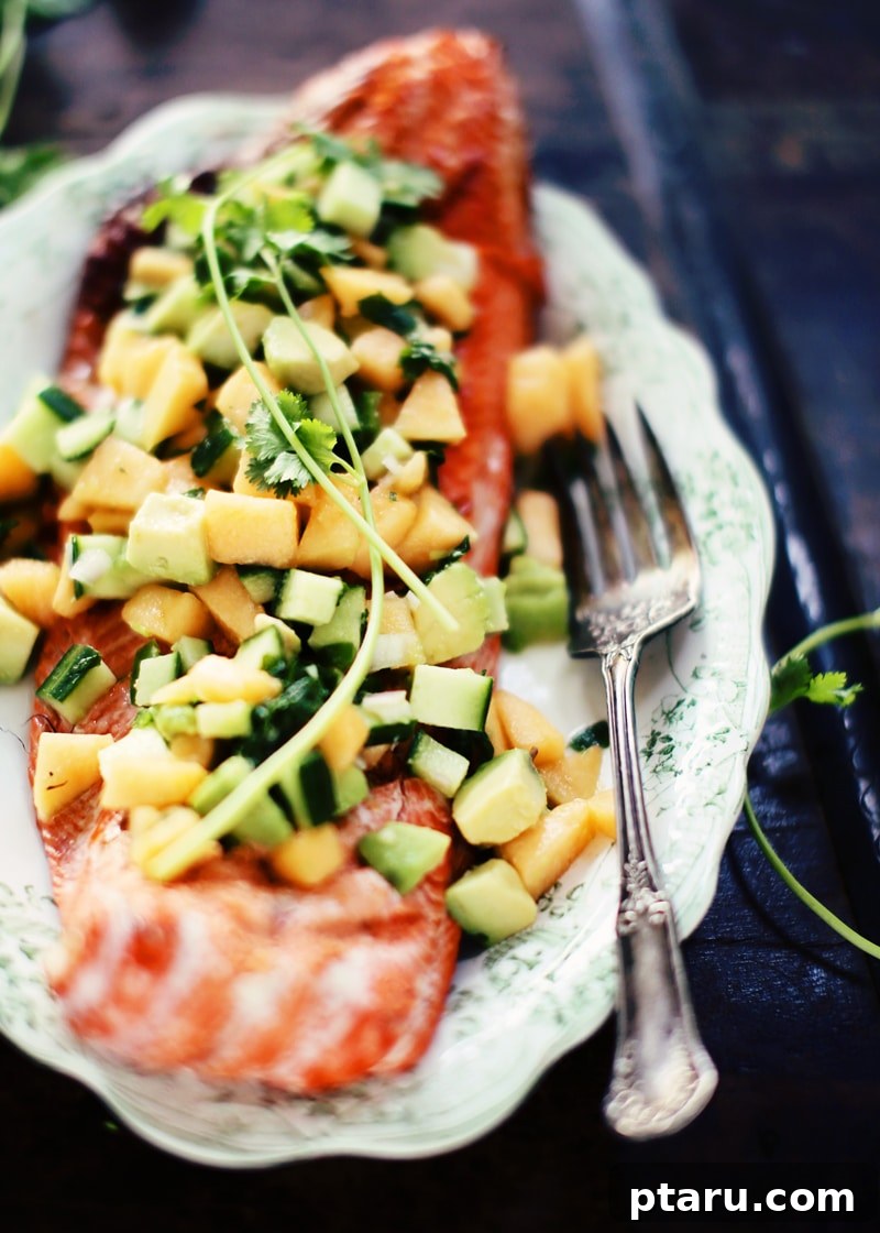 Grilled Salmon with Vibrant Avocado, Melon & Cucumber Salsa 3 Close-up of grilled salmon on the grates with a spatula, showing the perfect cook.