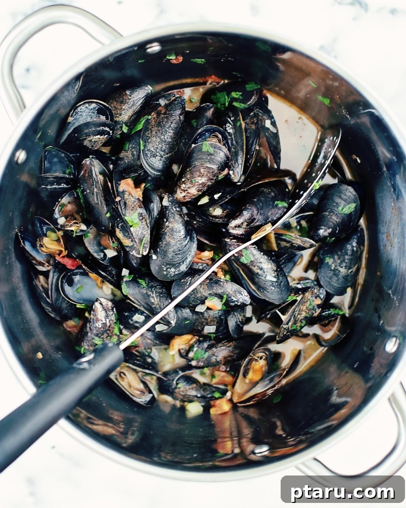 Beer-Kissed Mussels 5 A close-up of mussels and aromatics simmering in a pot.