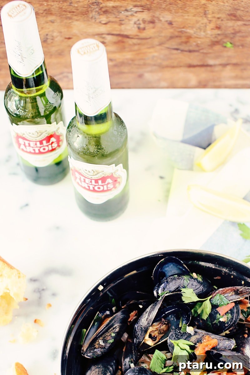 Beer-Kissed Mussels 6 A bowl of Stella Artois mussels served with fresh parsley and a glass of beer.