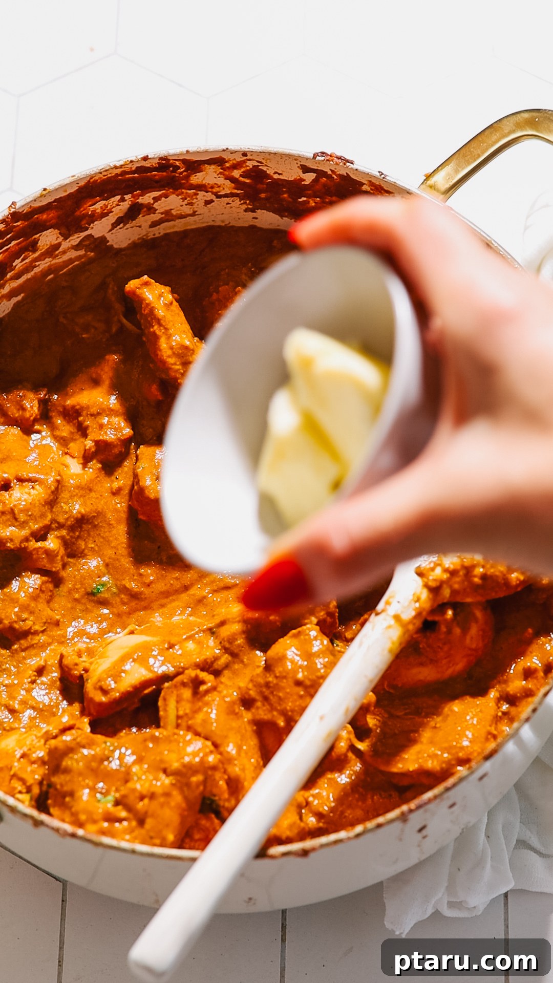 The Ultimate Butter Chicken Recipe: Restaurant-Level Perfection at Home 9 Adding butter to the butter chicken sauce.