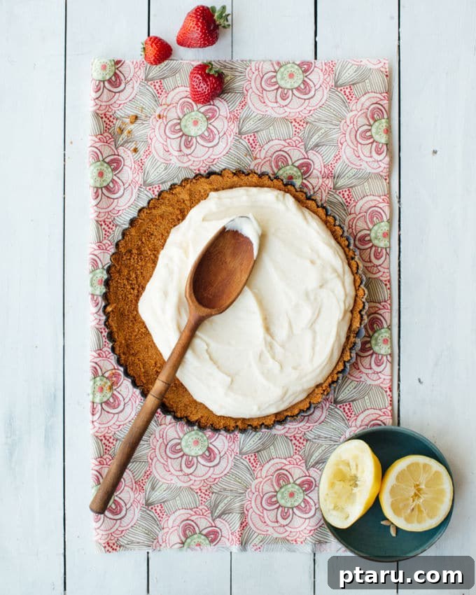 Strawberry Lemon Mascarpone Dream Tart 4 A slice of Strawberry-Lemon Mascarpone Cream Tart on a plate, showing the layers of crust, cream, and berries.