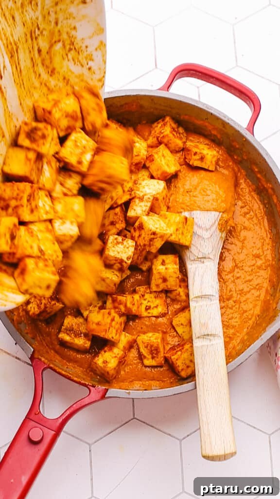 Creamy Butter Paneer 12 Marinated paneer cubes being added gently to the simmering butter paneer sauce in a pan.