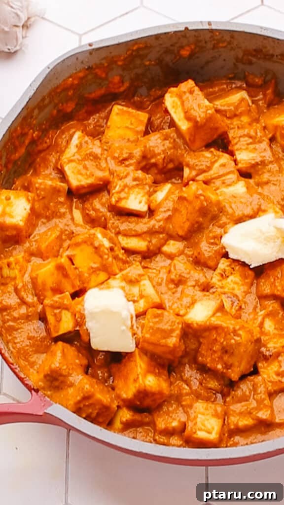 Creamy Butter Paneer 15 Adding a generous pat of butter to the simmering butter paneer masala sauce.