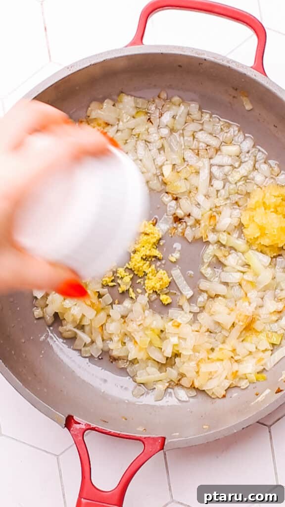 Creamy Butter Paneer 8 Onions, garlic, and ginger sautéing in a large saucepan, creating an aromatic base for the butter paneer gravy.