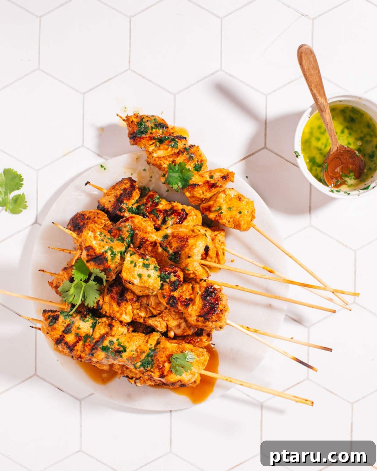 The Best Chicken Tikka Recipe For Grill Oven Or Air Fryer 6 Close-up of perfectly grilled and juicy chicken tikka pieces served on a white plate with fresh cilantro garnish.