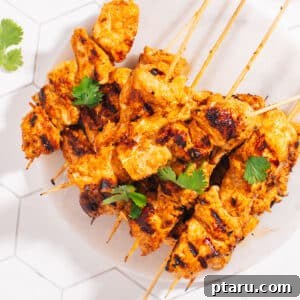 The Best Chicken Tikka Recipe For Grill Oven Or Air Fryer 7 Finished Chicken Tikka Recipe on a plate garnished with fresh cilantro, ready to be served.