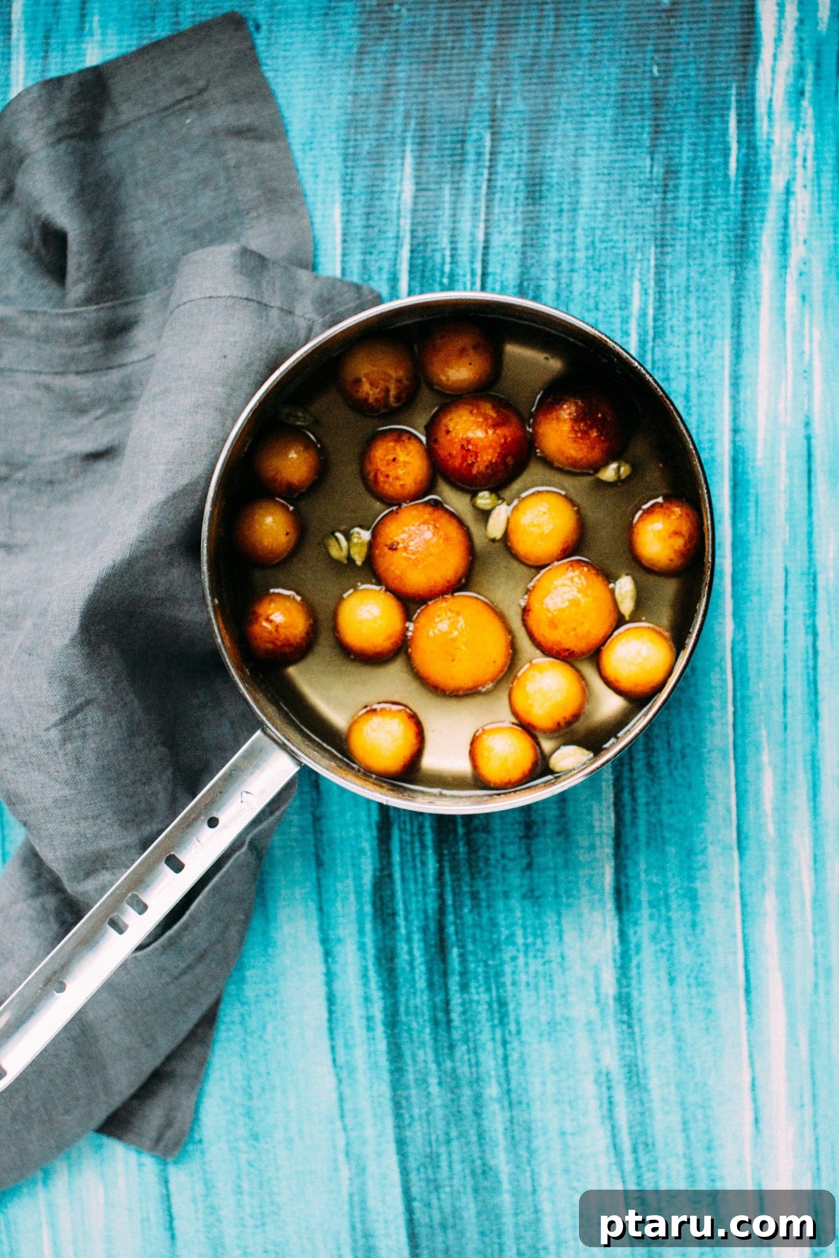 Easy Indian Desserts and Sweets: Crowd-Pleasing Showstoppers 3 Pillowy soft Gulab Jamun soaking in a shimmering sugar syrup on the stove, ready to be served.