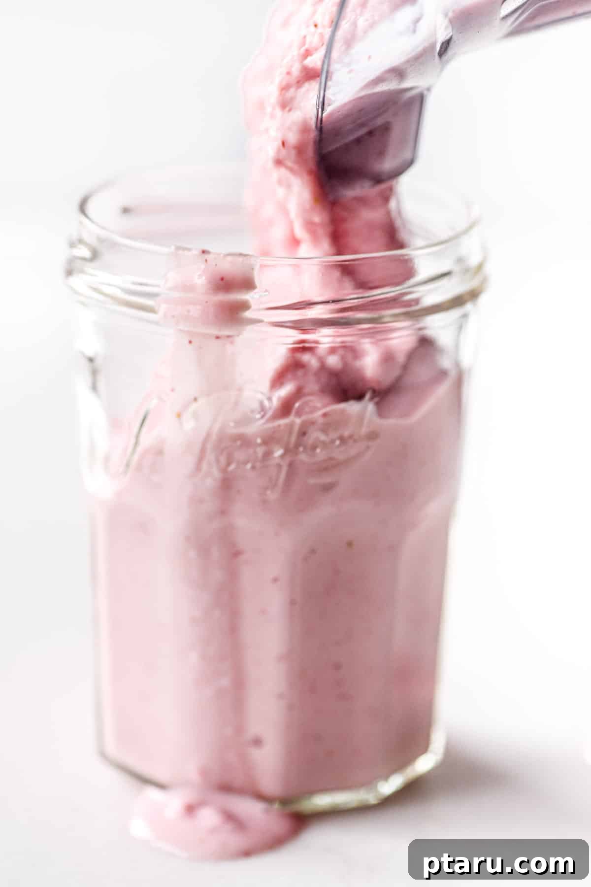 Favorite Easy Rhubarb Recipes You'll Make Forever 23 A tall glass of pink Rhubarb Smoothie garnished with fresh fruit.