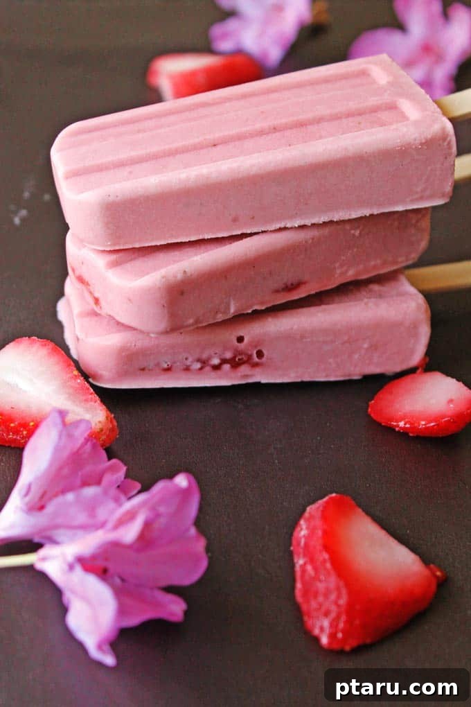 Favorite Easy Rhubarb Recipes You'll Make Forever 25 Vibrant pink Rhubarb + Strawberry Popsicles in a glass.
