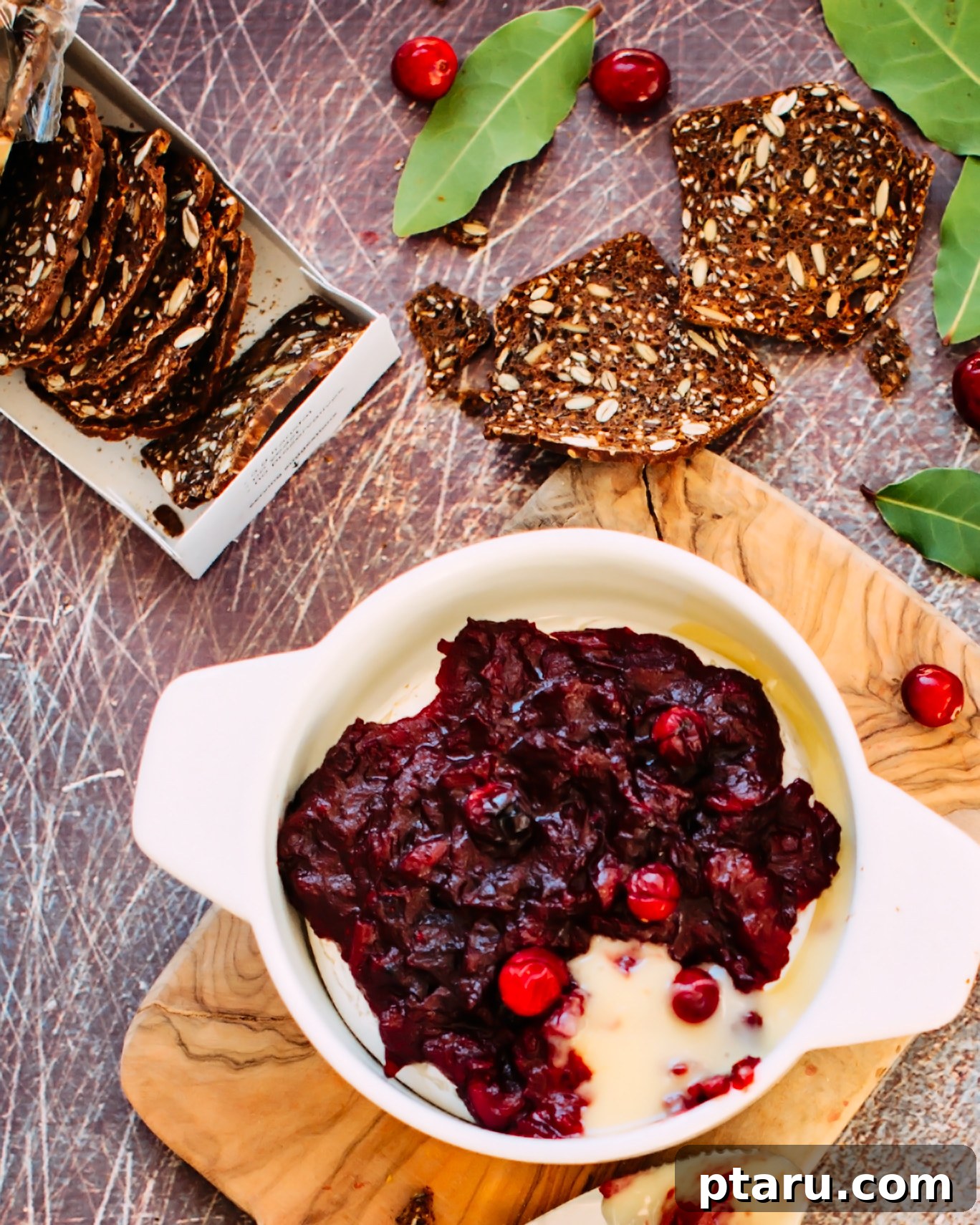 Warm Brie with Zesty Cranberry-Ginger Chutney 5 Baked Brie served in a dish with crackers and festive garnishes