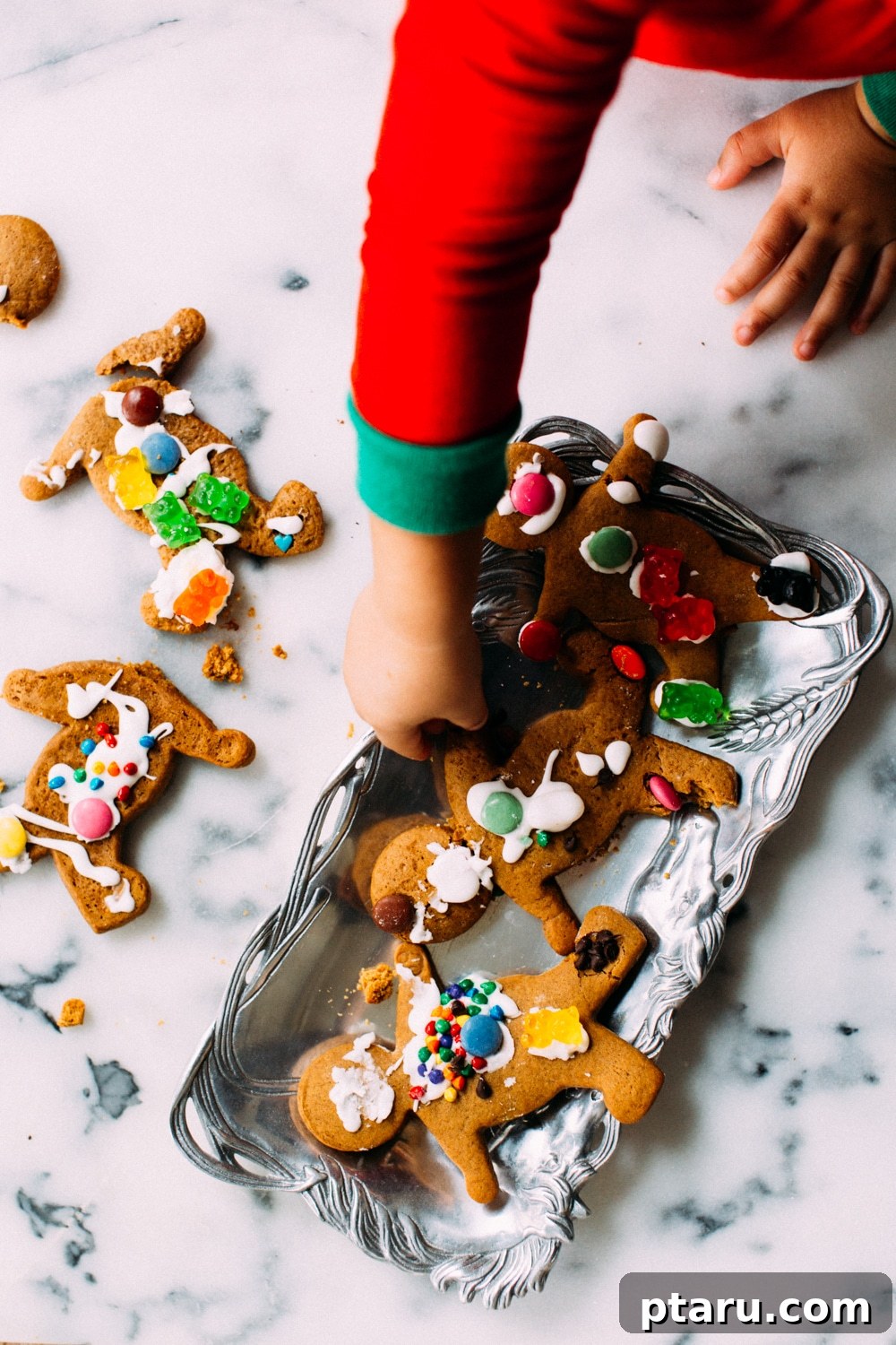 Irresistibly Soft and Chewy Gingerbread Men 3 A toddler decorating a gingerbread man with colorful candies and icing
