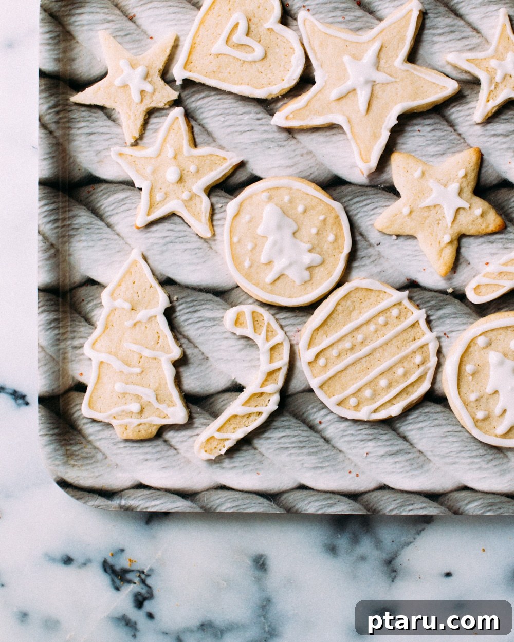 Foolproof Royal Icing 4 Hands meticulously decorating a heart-shaped cookie with white royal icing using a precise squeeze bottle, showcasing fine detail.