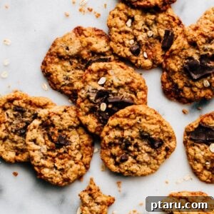 A plate full of freshly baked Toffee Oatmeal Chocolate Chunk Cookies, warm and inviting.