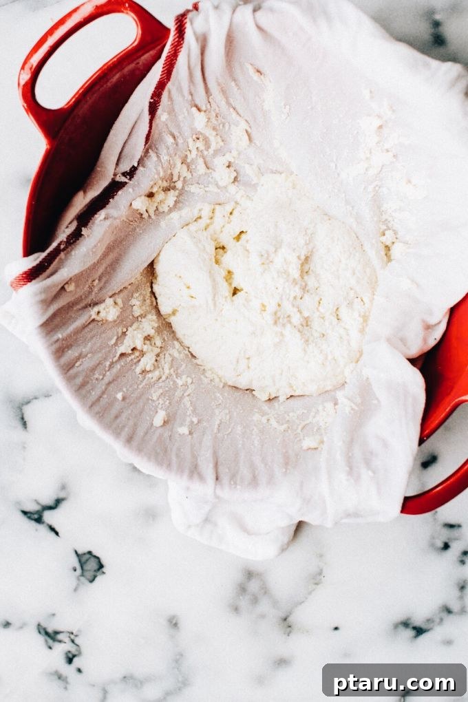 Effortless Homemade Paneer Your Step by Step Guide 7 Curdled milk being strained in a cheesecloth-lined colander.