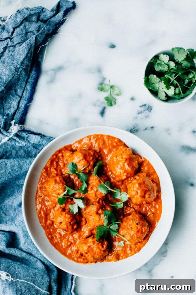 Simple Creamy Paneer Malai Kofta Curry 4 Malai Kofta in a serving bowl, garnished with fresh cilantro, ready to eat.